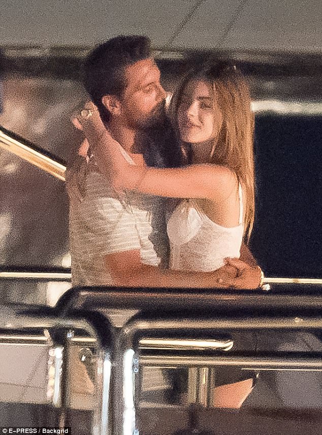Scott Disick hugging Bridget Satterlee, where Scott wears a white t-shirt and Bridget wearing a white top